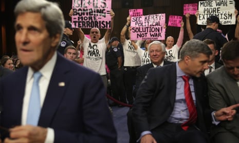 Members of CodePink stage a protest as John Kerry takes his seat at a hearing before the Senate.