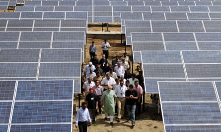 Gujarat Chief Minister Narendra Modi, center, walks among solar panels before inaugurating the 5 MW solar photovoltaic power plant at Khadoda, in Sabarkantha district, about 90 kilometers (56 miles) from Ahmadabad, India, Friday, June 10, 2011.