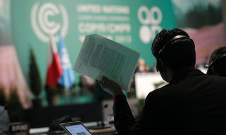 A man holds documents as he listens to statements of delegates during climate talks in Warsaw, Poland, in 2013