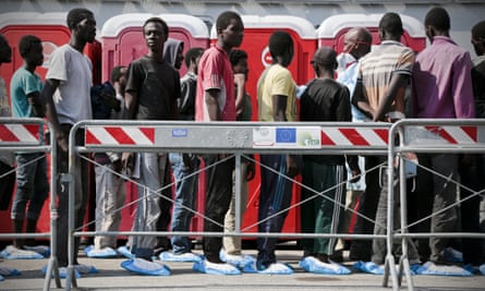 Disembarking immigrants wait to be processed by authorities in Naples after arriving aboard the tanker Virginio Fasan.