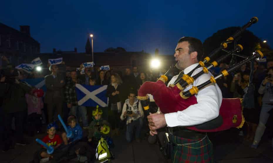 Yes campaigners are entertained by a piper outside the Scottish Parliament in Edinburgh.