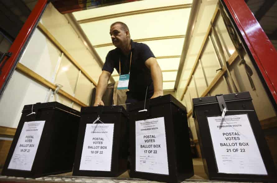 A man carries ballot boxes at a counting centre in Edinburgh.
