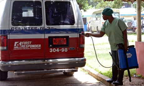 A health worker disinfects an ambulance at the John F Kennedy hospital in Monrovia, Liberia