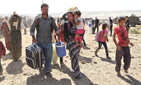 Syrians approach the Turkish border after fleeing Isis attacks on 60 Kurdish villages
