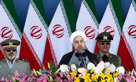 President Hassan Rouhani is hemmed in by Iran's military chiefs at a parade marking theIran-Iraq war