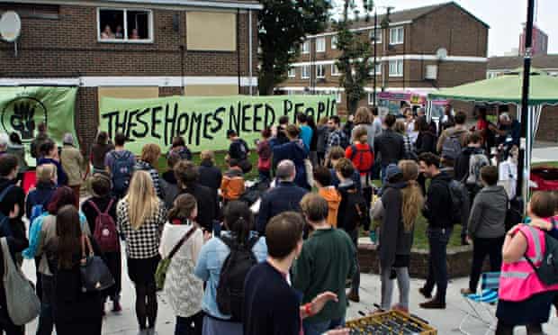 People outside a boarded-up council house occupied by Focus E15