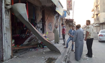 People inspect a shop damaged after what Islamist State militants say was a US drone in Raqqa.