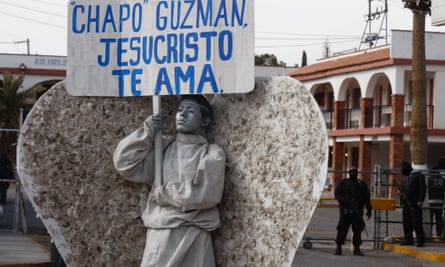 A member of an evangelical church dressed as angel holds a sign which reads, Chapo Guzman, Jesus Christ loves you during a demonstration against violence in the city of Ciudad Juarez.