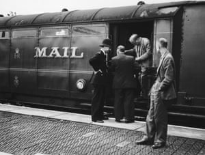 Police examining one of the coaches on the Glasgow to London travelling post office train near Bridego Railway Bridge in Buckinghamshire, England, the morning after the train was attacked and robbed in the 2.6 million pound 'Great Train Robbery', 8th August 1963.