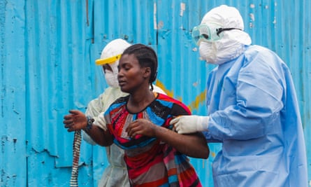 Liberian nurses escort a suspected Ebola patient into a treatment center in Monrovia