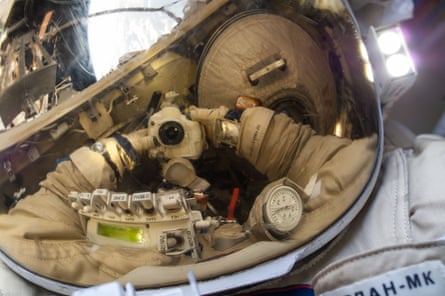 Russian cosmonaut Oleg Artemyev, Expedition 40 flight engineer, uses a digital still camera to expose a photo of his helmet visor