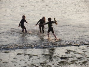 Enjoying a seaweed fight after a sunset swim Sun set, incoming tide; young girls enjoy a seaweed fight after a wedding BBQ. 14 September 2014