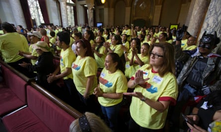 Hotel workers applaud prior to a city council vote to increase minimum wage at in Los Angeles.