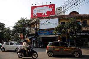 People ride past a big poster hung on a roof which reads 'Rhino horns are just like buffalo horns, human hair and nail. Do not waste your money', in Hanoi, Vietnam, 22 September 2014. World Rhino Day this year is marked on 22 September, with the theme 'Five Rhino Species Forever'.