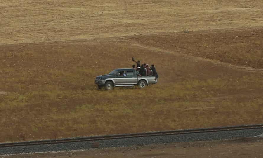 Turkish Kurds load a pick-up after they cross the border to join Syrian Kurdish fighters in Kobani