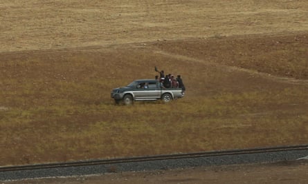 Turkish Kurds load a pick-up after they cross the border to join Syrian Kurdish fighters in Kobani