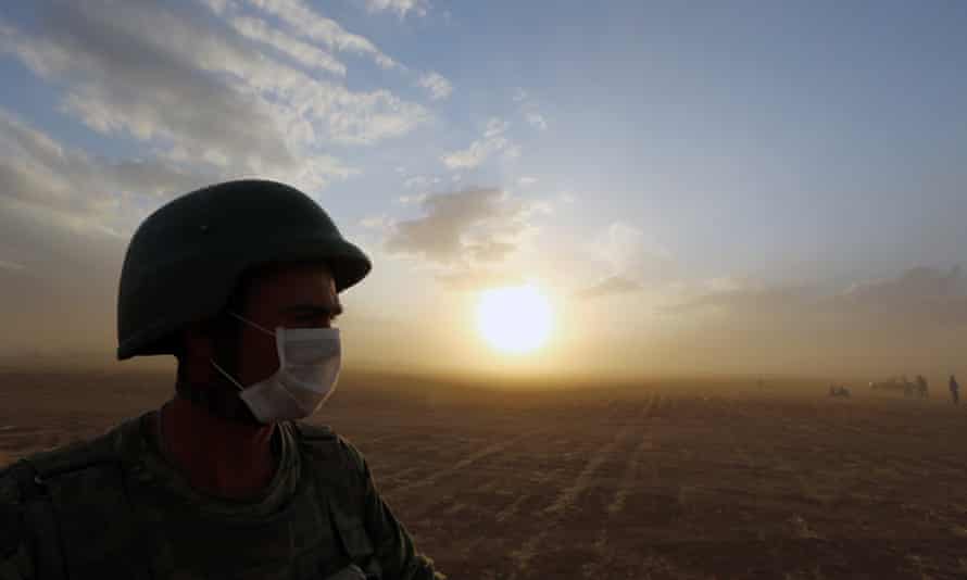 A Turkish soldier stands guard at the Syrian border near Suruc