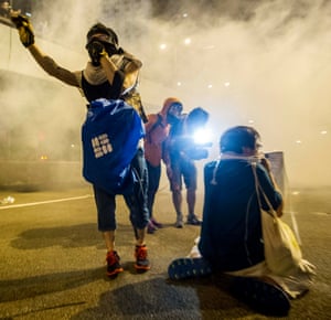 Protesters protect themselves from tear gas fired by police during riots that followed a pro-democracy protest in Hong Kong.