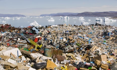 Rubbish dumped on the tundra outside llulissat in Greenland with icebergs behind from the Sermeq Kujullaq or llulissat Ice fjord. The Ilulissat ice fjord is a Unesco world heritage site