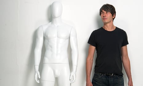 Physicist Brian Cox in a T-shirt looking at a shop mannequin