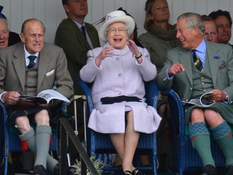 Prince Philip, the Queen and Prince Charles cheer as competitors participate in a sack race at the Braemar Gathering in Braemar in September 2012.