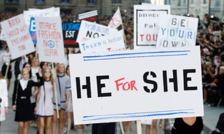A model holds a sign reading 'He for She' on the Chanel catwalk.