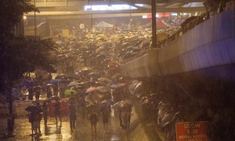 Pro-democracy protesters hold umbrellas to shelter from heavy rain in front of the Hong Kong government offices on day three of the mass civil disobedience campaign Occupy Central in, Hong Kong, China, 30 September 2014.