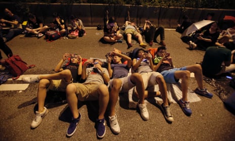 Student protesters rest as thousands occupy a main thoroughfare in Hong Kong, late Tuesday, Sept. 30, 2014.