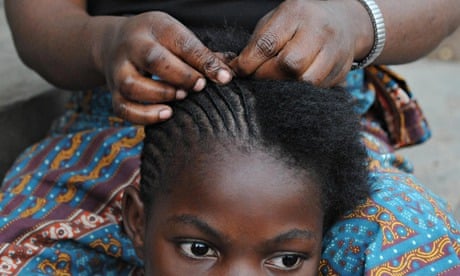 A Congolese woman braids the hair of a girl at a residence for rape victims in Goma