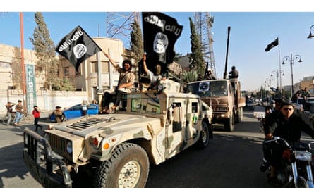Isis fighters drive a US-made Humvee  along the streets of Syria's northern Raqqa province