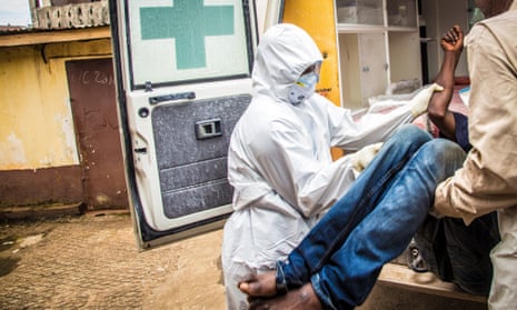 Red Cross workers load a suspected Ebola case into an ambulance in Freetown, Sierra Leone, in September. Freetown still has a relatively large number of cases.