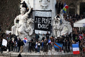 People climb on the statues at the Place de la Republique