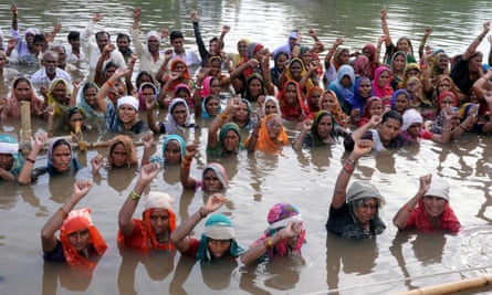 In an unusual way of protesting, some 51 affected villagers under the banner of the Narmada Bachao Andolan (NBA)   stand  in chin-deep water demanding land to replace lost land which was submerged after the water level in Omkareshwar dam and Indira Sagar dam was raised, according to reports,  in Khandwa, Madhya Pradesh, India, 4 September 2012.