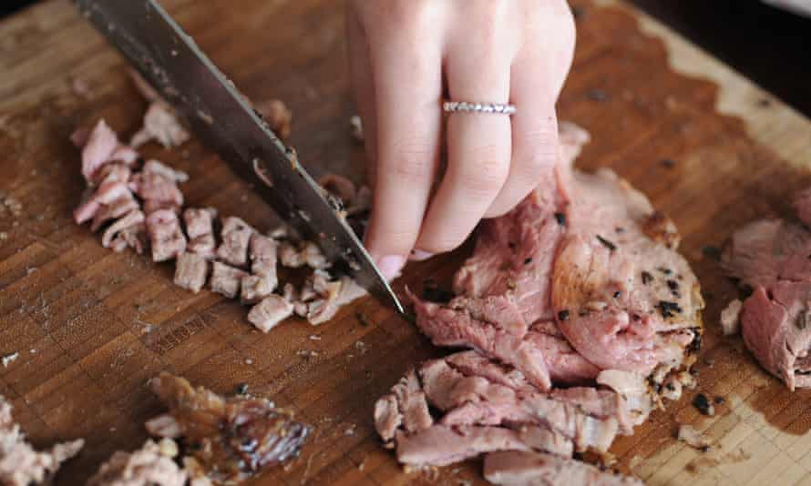 a lady chopping up leftover lamb