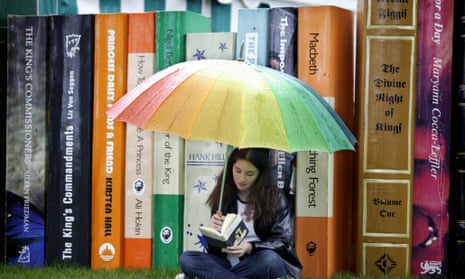 Teenager reading at Hay on Wye under an umbrella