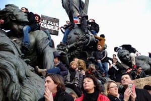 People climb the statue Le Triomphe de la République at Place de la Nation in Paris during a rally to show unity and defiance after the Charlie Hebdo attack. An estimated 3.7 million people across France marched in solidarity.