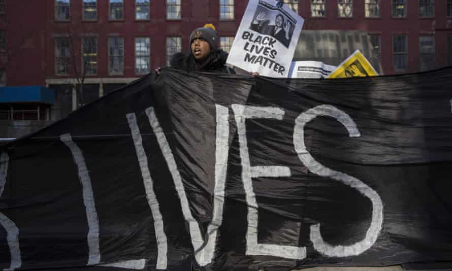 A demonstrator holds a banner during a protest against police violence towards minorities.