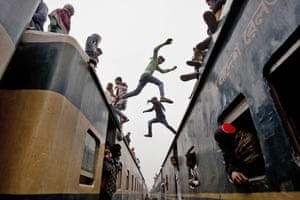 Bangladeshi boys jump from the top of one overcrowded train to another as thousands of people return home after a three-day Islamic congress on the banks of the river Turag.