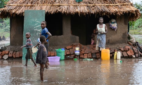 A family wait outside their home for relief teams in the district of Chikwawa, near Blantyre.