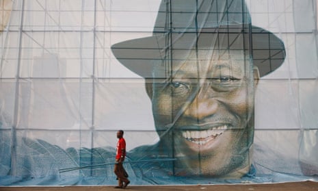 A man walks past a portrait of Nigeria's President Goodluck Jonathan