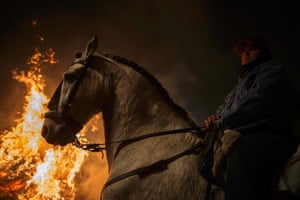 San Bartolome de los Pinares, Spain A man and his horse stand near a fire during the annual religious celebration of Luminariason the night before Saint Anthony's, patron of animals