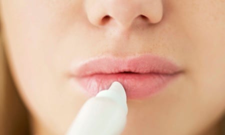 A girl applies lip balm