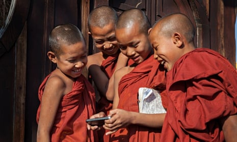 Young monks gathering around iphone