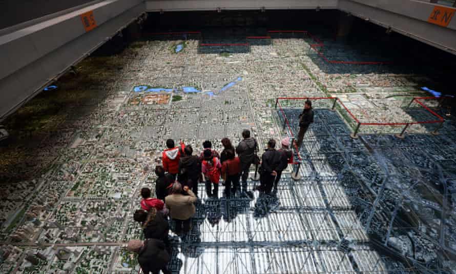 Visitors look at a model of the city of Beijing at the Beijing Planning Exhibition Hall in Beijing, China, on Wednesday, March 6, 2013.