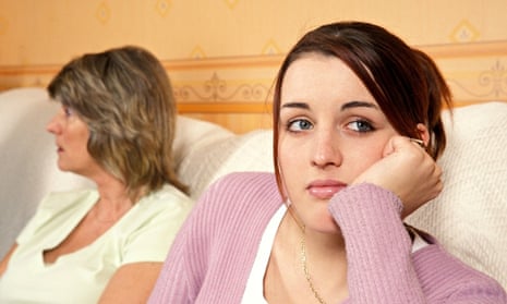 Teenager next to her mother, looking away unhappily