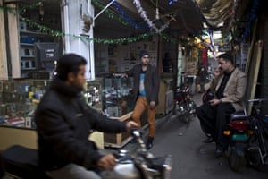 Waseem Akram stands by the mobile shop where he works during the day