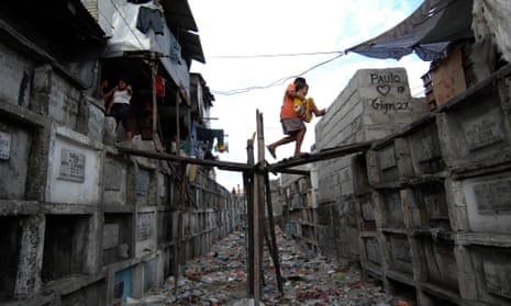 Filipino children walk between the tombs of the Municipal Cemetery of Navotas, north of Manila, where they live.
