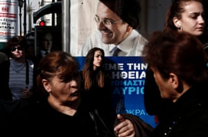 Athens, Greece People stand at a bus stop decorated with an electoral poster of Greece's Prime Minister and ruling conservative New Democracy party leader Antonis Samaras. An early national election will be held this weekend after the Greek parliament failed to elect a president