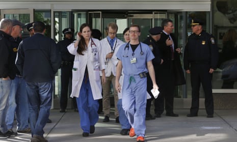 Medical personnel walk past law enforcement officials at Brigham and Women’s Hospital after Dr Michael J Davidson was shot.