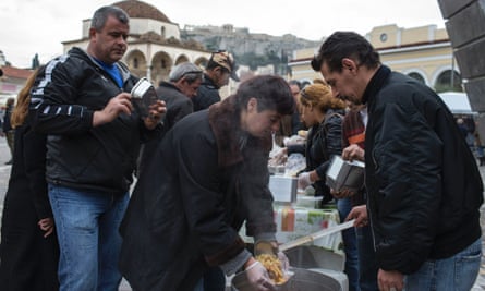 People queue for food at a soup kitchen in Athens.